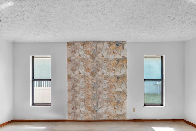 1290 SE Mcfarlane Ave, Port Saint Lucie, FL 34952 - tiled empty room with plenty of natural light, a textured ceiling, and baseboards