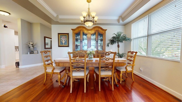 15511 63rd Pl N, Loxahatchee, FL 33470 - dining space featuring a chandelier, a raised ceiling, light wood-style flooring, crown molding, and baseboards