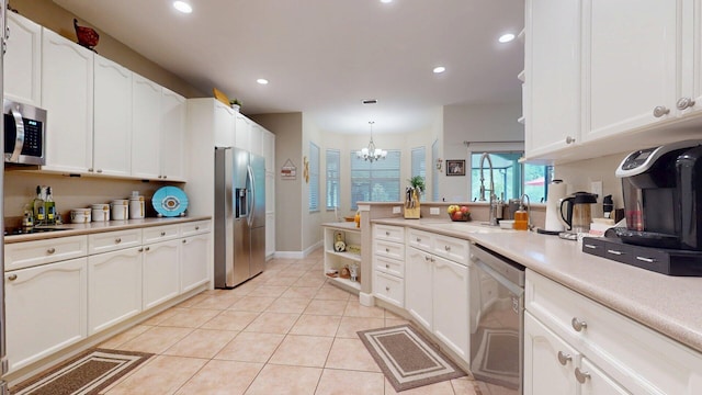 15511 63rd Pl N, Loxahatchee, FL 33470 - kitchen with stainless steel appliances, a peninsula, a chandelier, white cabinetry, and recessed lighting