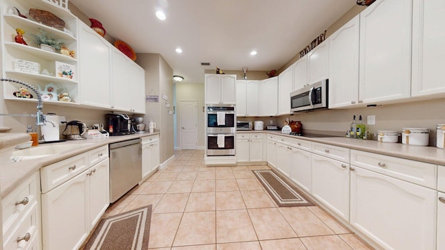 15511 63rd Pl N, Loxahatchee, FL 33470 - kitchen featuring appliances with stainless steel finishes, light tile patterned floors, recessed lighting, open shelves, and white cabinetry