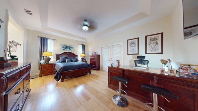 15511 63rd Pl N, Loxahatchee, FL 33470 - bedroom with a raised ceiling, light wood finished floors, and a ceiling fan