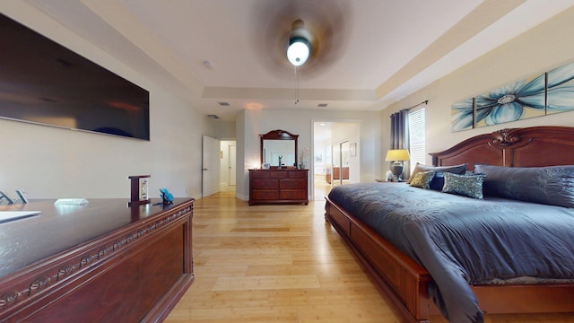 15511 63rd Pl N, Loxahatchee, FL 33470 - bedroom featuring a raised ceiling, light wood-style flooring, and ensuite bathroom