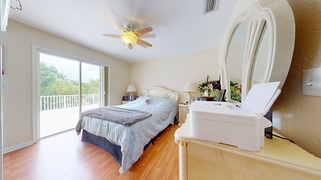 15511 63rd Pl N, Loxahatchee, FL 33470 - bedroom featuring light wood-type flooring, access to outside, ceiling fan, and a textured wall