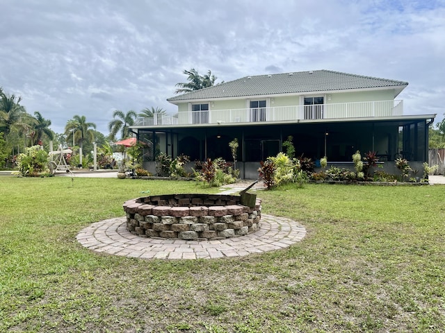 15511 63rd Pl N, Loxahatchee, FL 33470 - rear view of property featuring an outdoor fire pit, a sunroom, a yard, and a balcony