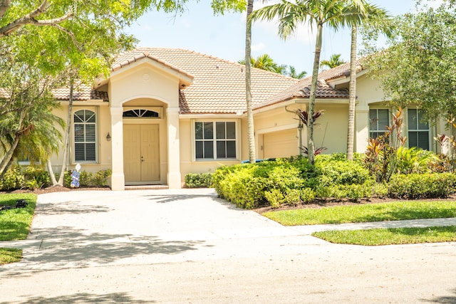 1366 Crossbill Ct, Weston, FL 33327 - mediterranean / spanish-style house with a garage, a tile roof, stucco siding, and driveway