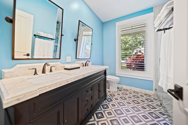 5211 SW Bimini Cir N, Palm City, FL 34990 - bathroom featuring toilet, double vanity, tile patterned floors, and baseboards