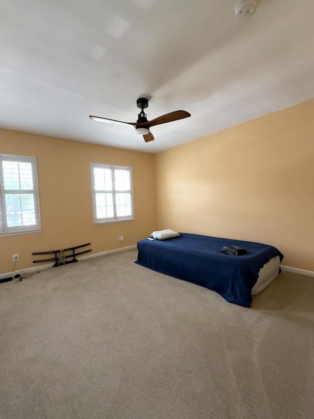 unfurnished bedroom with baseboards, carpet flooring, and a ceiling fan