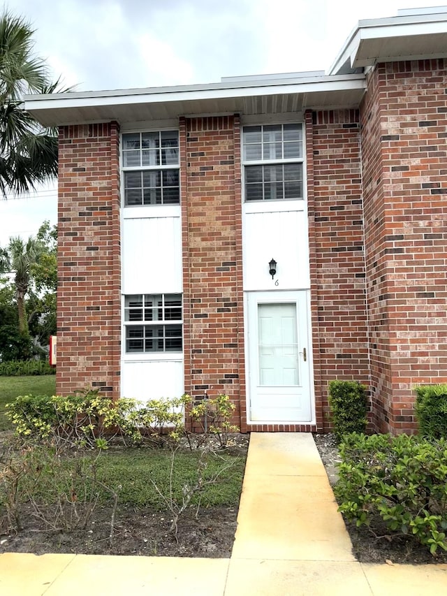 doorway to property featuring brick siding
