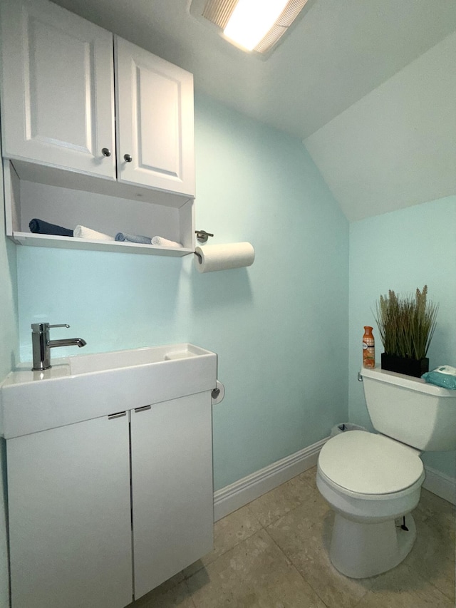 bathroom featuring baseboards, toilet, vanity, and lofted ceiling