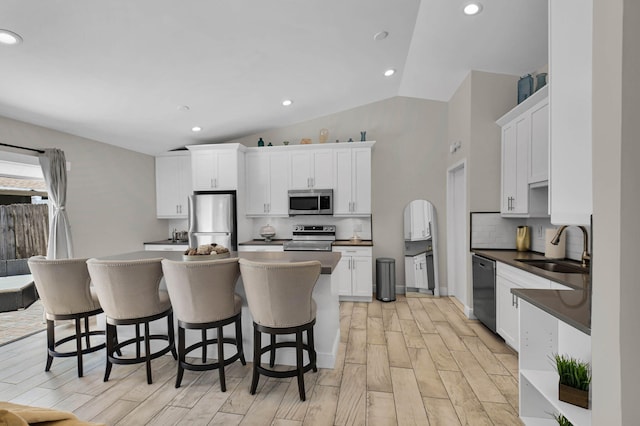 9794 Ridgecreek Rd, Boca Raton, FL 33496 - kitchen with appliances with stainless steel finishes, a sink, a center island, tasteful backsplash, and vaulted ceiling