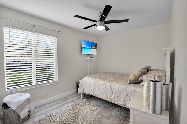 9794 Ridgecreek Rd, Boca Raton, FL 33496 - bedroom with multiple windows, baseboards, light wood-style flooring, and ceiling fan