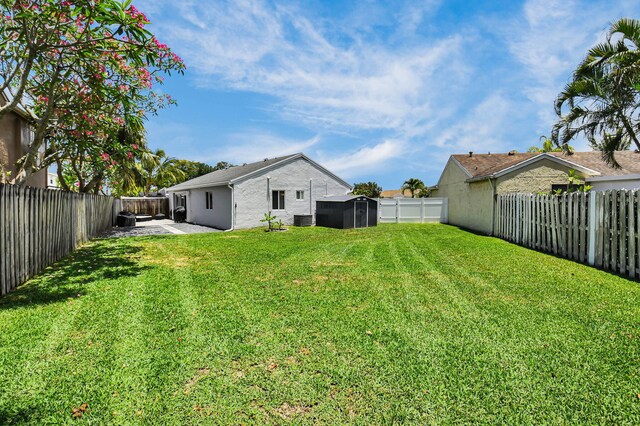9794 Ridgecreek Rd, Boca Raton, FL 33496 - view of yard featuring a storage shed, an outbuilding, central AC unit, and a patio area