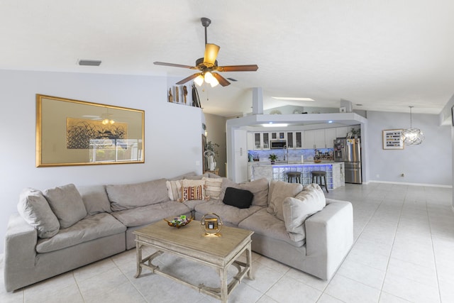 living area with vaulted ceiling, light tile patterned floors, and a ceiling fan