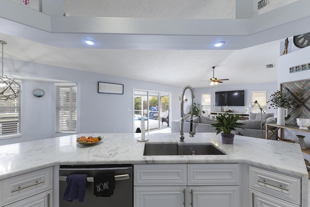 kitchen with dishwashing machine, a sink, ceiling fan, light stone countertops, and white cabinets