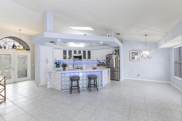 kitchen with stainless steel appliances, light tile patterned floors, tasteful backsplash, and light countertops