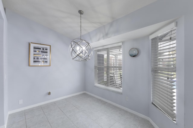 unfurnished dining area with a chandelier, tile patterned flooring, and baseboards
