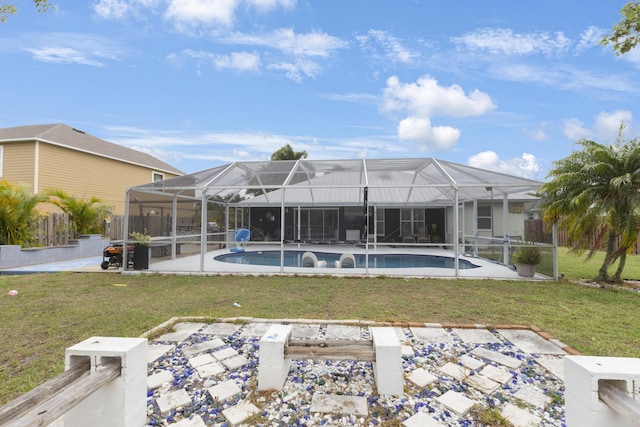 rear view of property featuring a patio area, an outdoor pool, and a yard