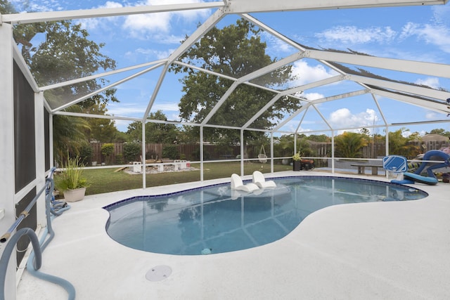 view of pool with a patio area and glass enclosure