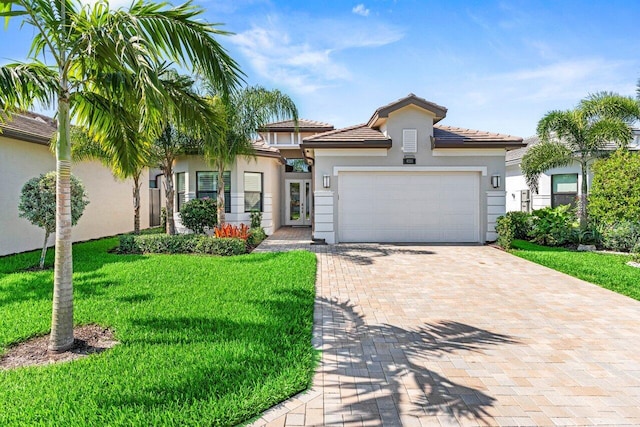 9333 Mountain Pine Grv, Boynton Beach, FL 33473 - view of front facade featuring stucco siding, decorative driveway, a garage, and a front lawn