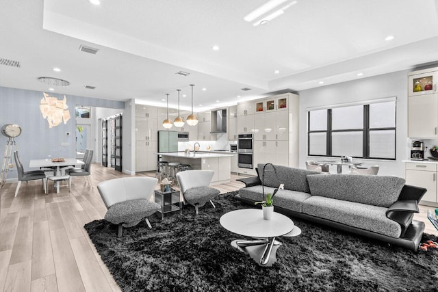 9333 Mountain Pine Grv, Boynton Beach, FL 33473 - living room with light wood finished floors, recessed lighting, plenty of natural light, a chandelier, and a tray ceiling