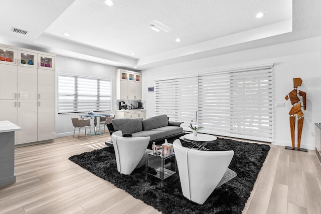9333 Mountain Pine Grv, Boynton Beach, FL 33473 - living room with a tray ceiling, light wood-type flooring, baseboards, a textured ceiling, and recessed lighting