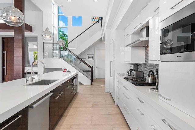 120 N Gordon Rd Share A, Unit Share A, Fort Lauderdale, FL 33301 - kitchen featuring modern cabinets, stainless steel appliances, wall chimney range hood, a sink, and light countertops