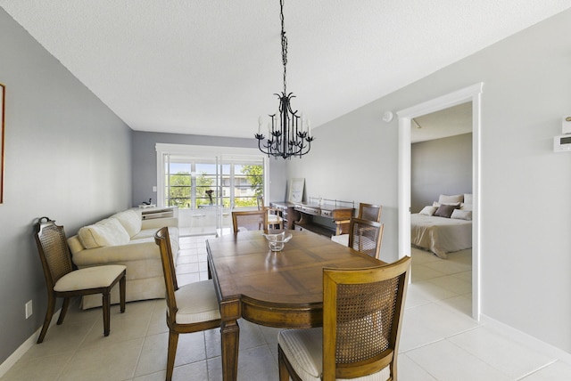 dining room featuring a chandelier, light tile patterned floors, and baseboards