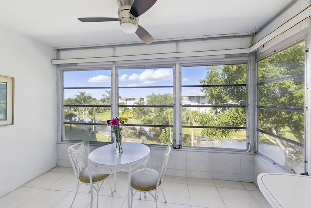 sunroom featuring a ceiling fan and tile patterned floors