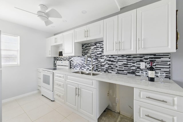 kitchen with white electric range, a sink, tasteful backsplash, and white cabinetry