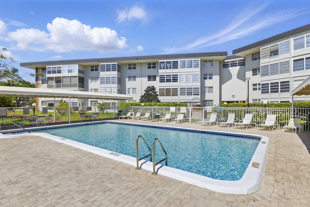 community pool featuring fence and a patio