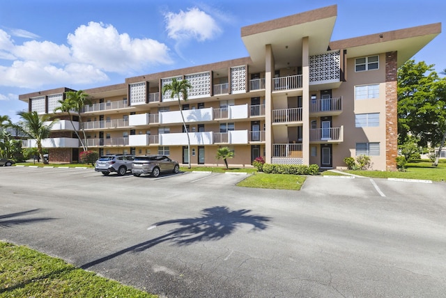 view of apartment building / complex featuring uncovered parking