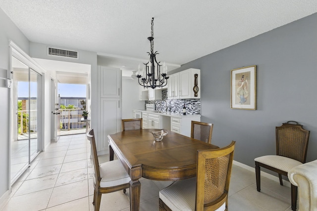 dining space with a chandelier, baseboards, and light tile patterned floors