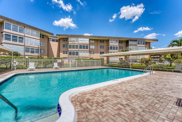 community pool with fence and a patio