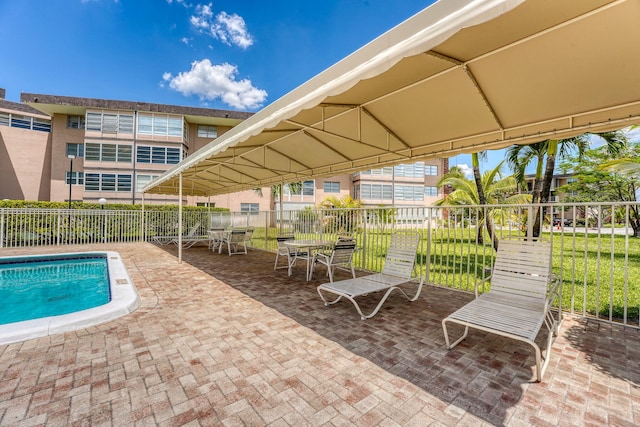view of swimming pool featuring fence and a patio