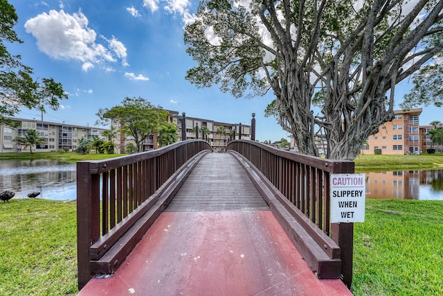 surrounding community featuring a lawn and a water view