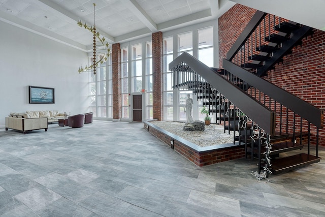 community lobby with a towering ceiling, stairway, and beam ceiling