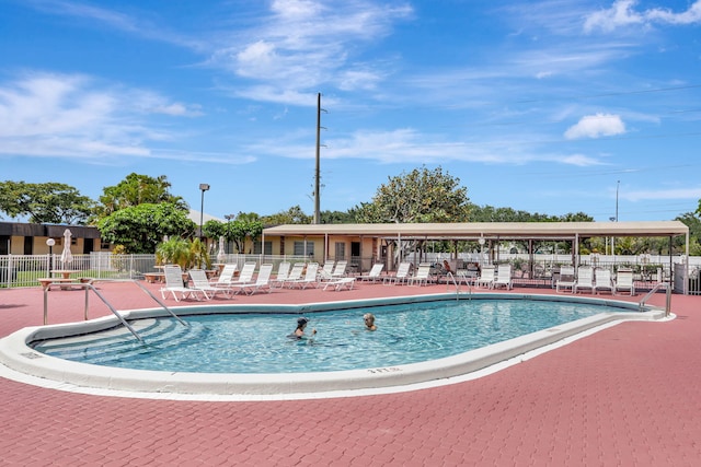 view of swimming pool featuring fence and a patio