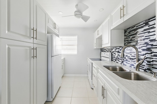 kitchen featuring white appliances, a sink, backsplash, baseboards, and white cabinetry