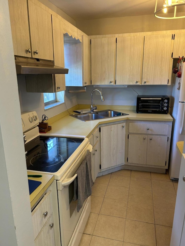 kitchen featuring white appliances, a sink, under cabinet range hood, light countertops, and light tile patterned floors