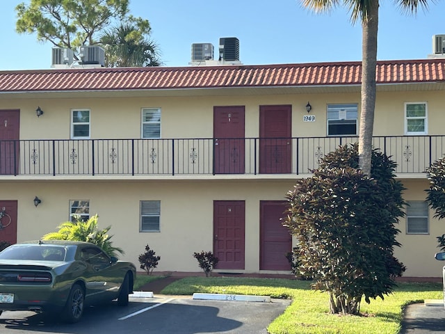 view of building exterior featuring central AC unit and uncovered parking