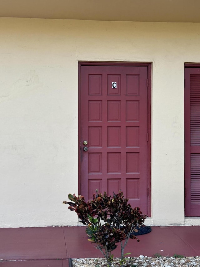 entrance to property featuring stucco siding