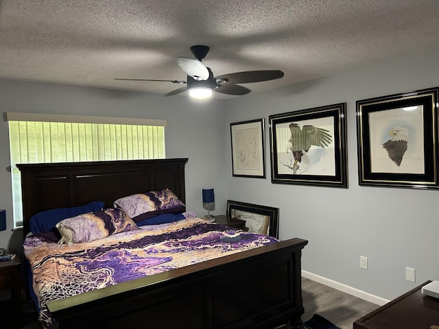 bedroom featuring dark wood-style floors, a textured ceiling, baseboards, and ceiling fan