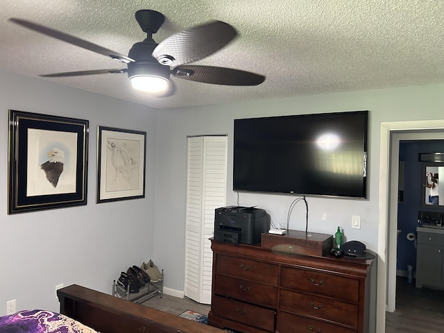 bedroom with a textured ceiling, wood finished floors, ceiling fan, and baseboards