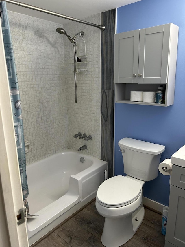 full bath with wood finished floors, shower / bath combo, vanity, toilet, and baseboards