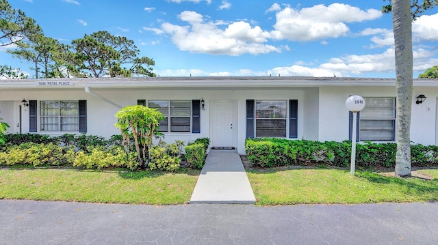 5048 Petal Pl Unit C, Delray Beach, FL 33484 - view of front facade featuring stucco siding and a front yard