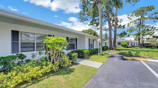 5048 Petal Pl Unit C, Delray Beach, FL 33484 - view of side of home with stucco siding and a lawn