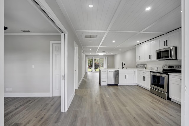5048 Petal Pl Unit C, Delray Beach, FL 33484 - kitchen featuring appliances with stainless steel finishes, a peninsula, recessed lighting, open floor plan, and light wood-type flooring