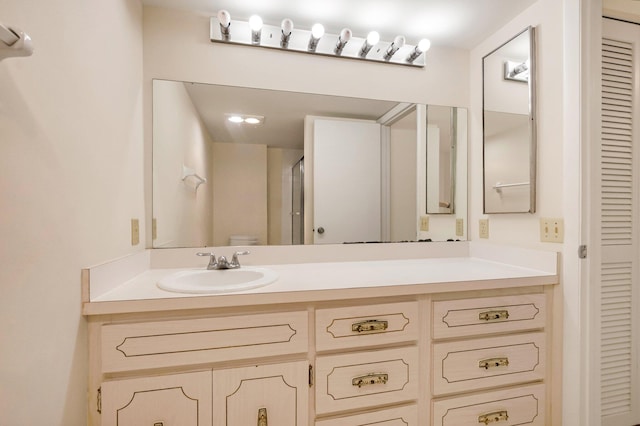 bathroom featuring a closet, vanity, and toilet