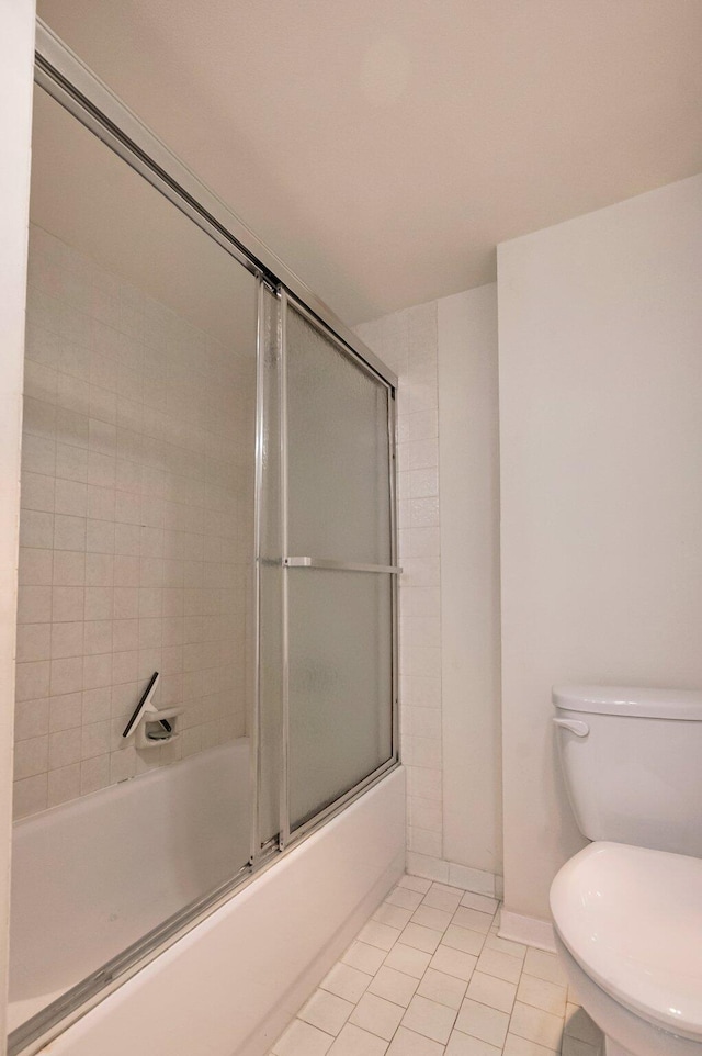 bathroom with tile patterned floors, enclosed tub / shower combo, and toilet