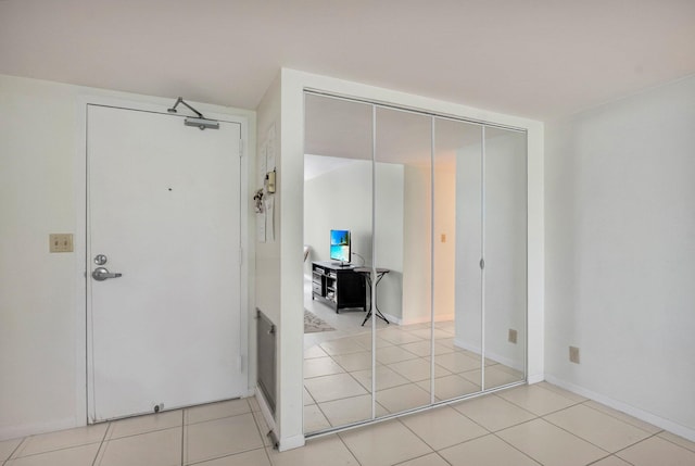 interior space featuring light tile patterned floors, baseboards, and a closet